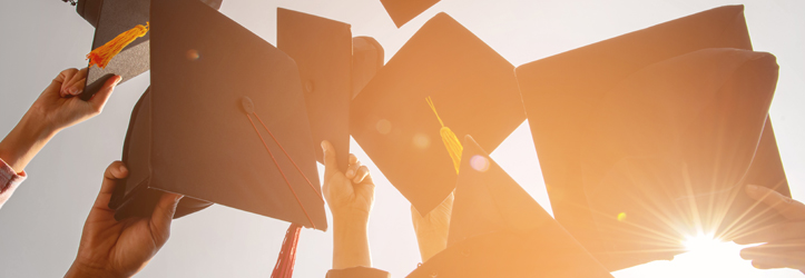 image représentant des étudiants lançant leur chapeau de diplômé